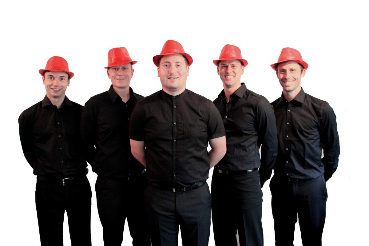 Die Sänger von sixpack acapella in schwarzen Hemden mit roten Hüten