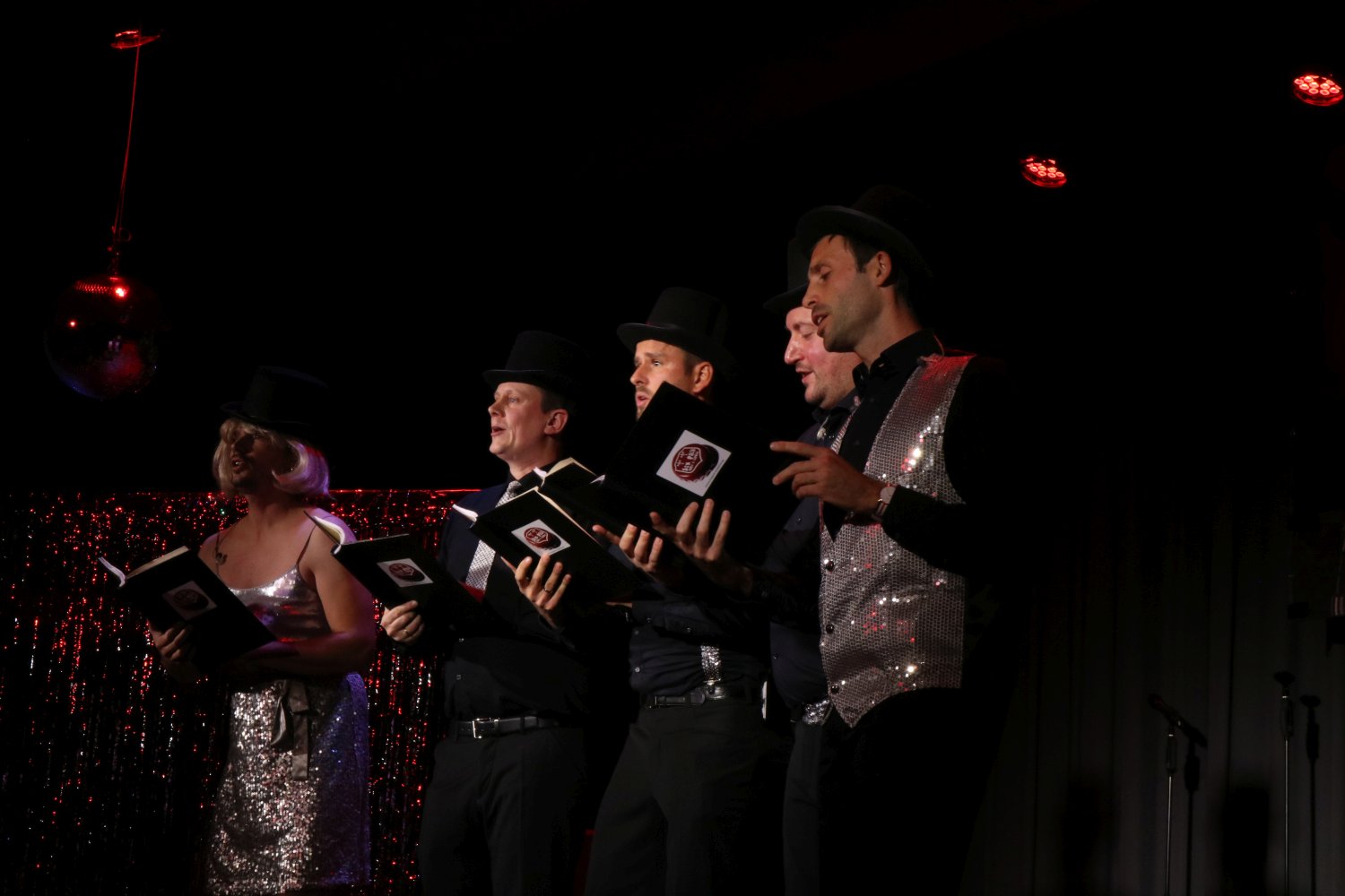 sixpack acapella mit Zylindern und Notenmappen auf der Bühne